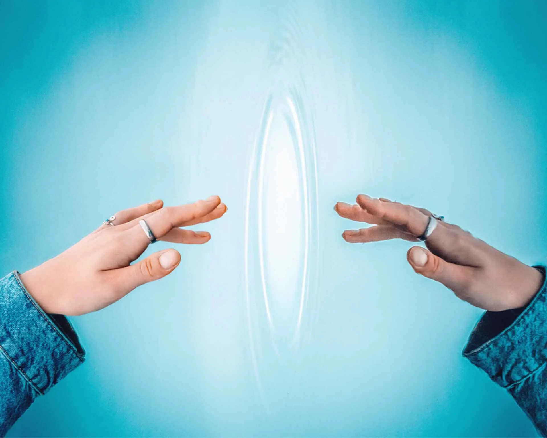 An altered reality shot of a hand reaching out to touch its own reflection in clear blue water